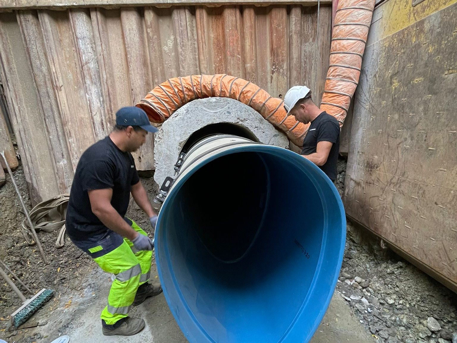 Canalisateurs SA LA GARONNE posant à la main une canalisation d'assainissement de grand diamètre dans une tranchée blindée, à Toulouse